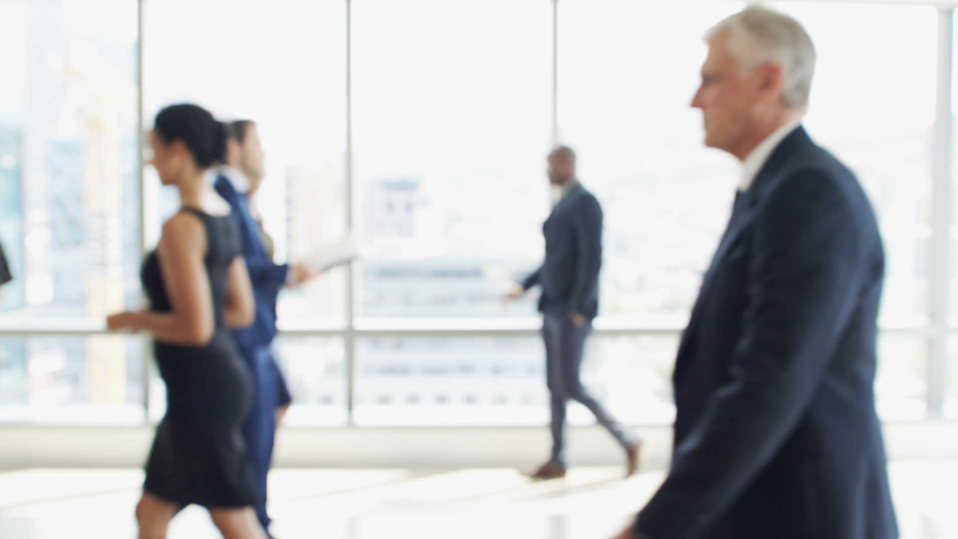 unfocused image of professionals in the common area of a commercial real estate office